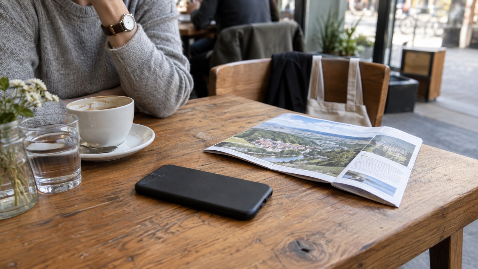 Phone and travel brochure on a café table. Generated illustration.