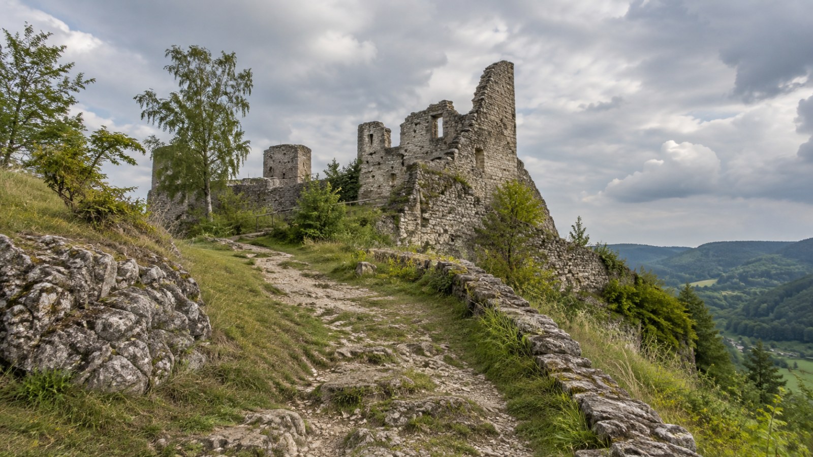 Footpath approaching the ruins of a stone castle. Generated illustration.